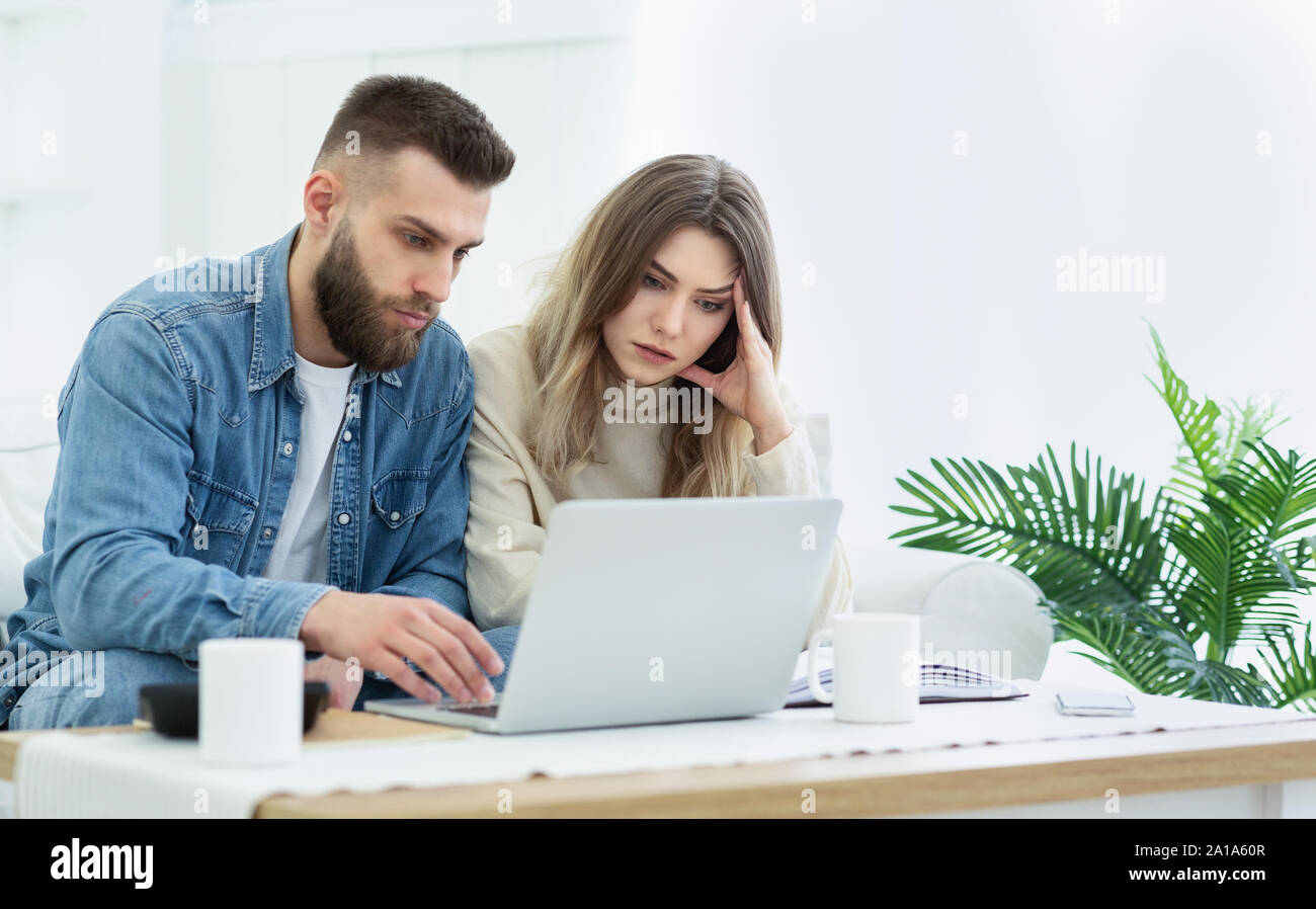 Young couple using laptop for managing expanses Stock Photo