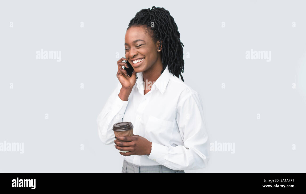 Office Girl Talking On Phone Holding Coffee Cup In Studio Stock Photo