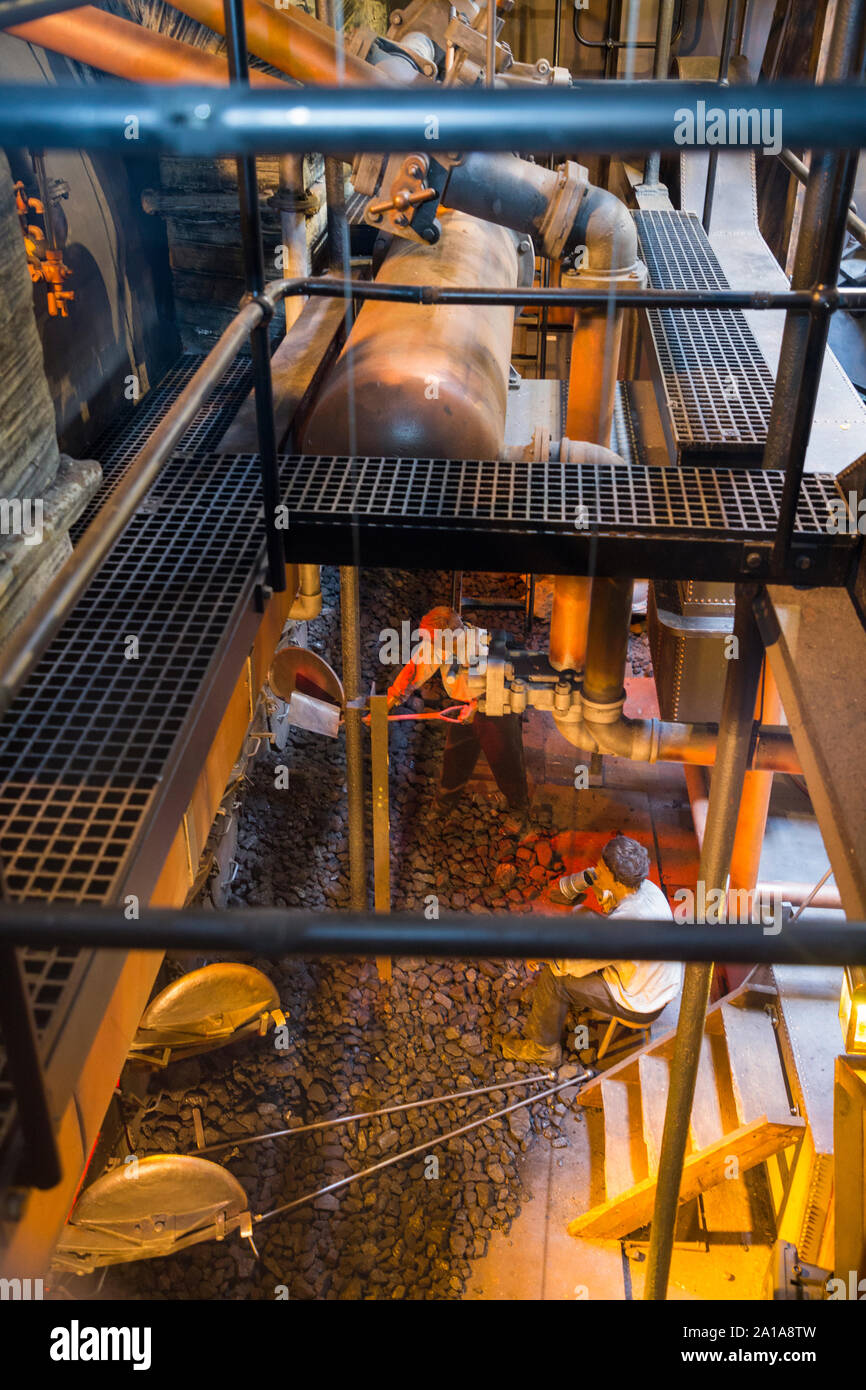 Re-created Engine room and furnace being fed coal by mannequin model figures; engine of the SS Great Britain, Brunel's steam powered ship in dry dock in in Bristol. UK England (109) Stock Photo