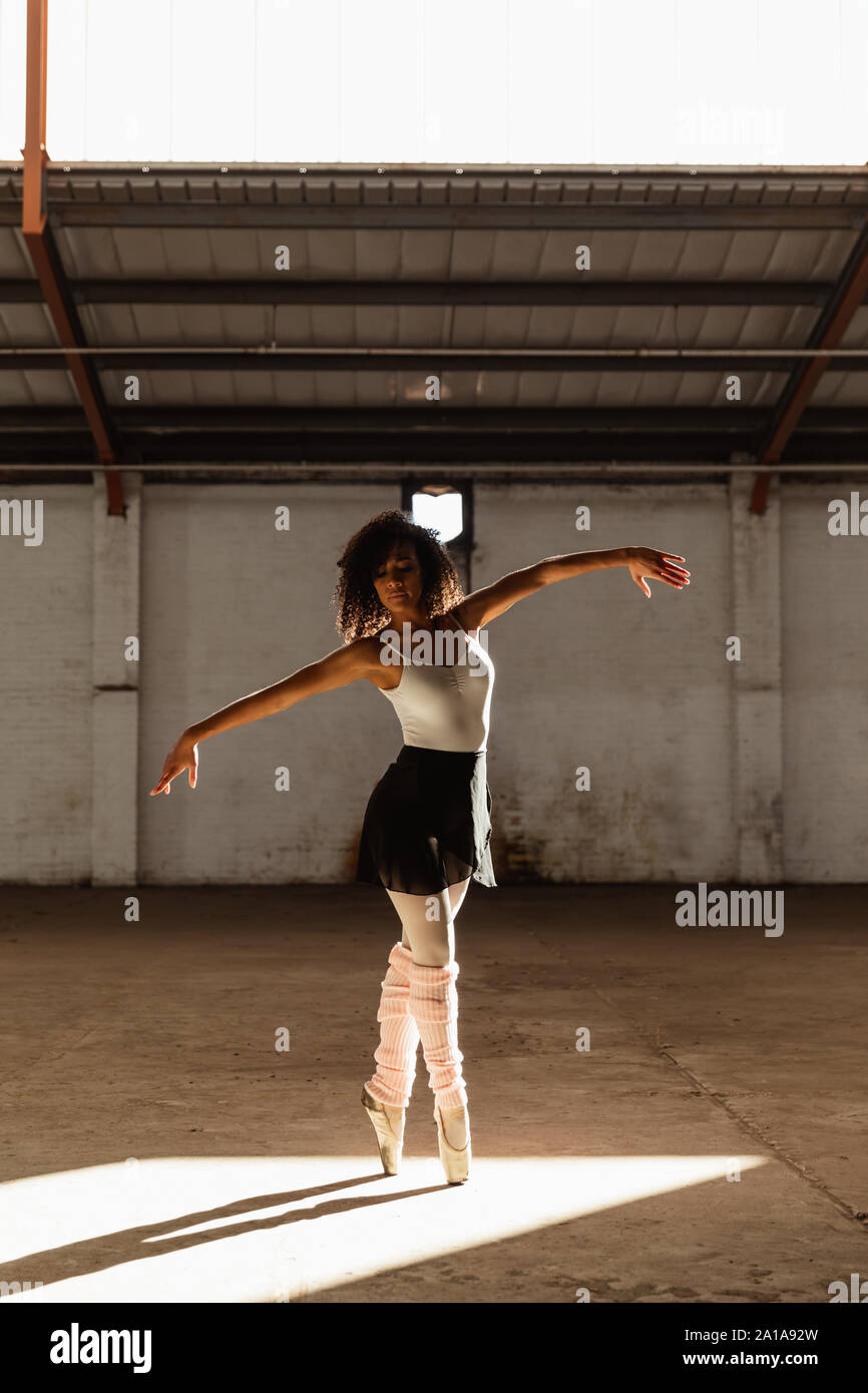Female dancer in an empty warehouse Stock Photo