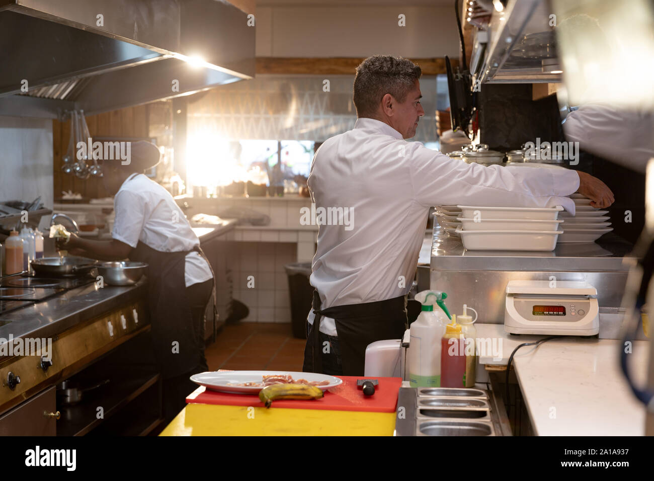 Chefs working in busy restaurant kitchen Stock Photo