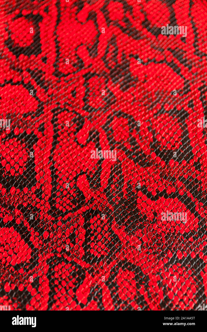 Texture of synthetic red snake skin for various purposes.Selective focus with shallow depth of field. Stock Photo