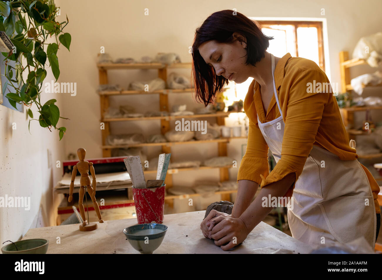 Female potter in a pottery studio kneading clay Stock Photo Alamy