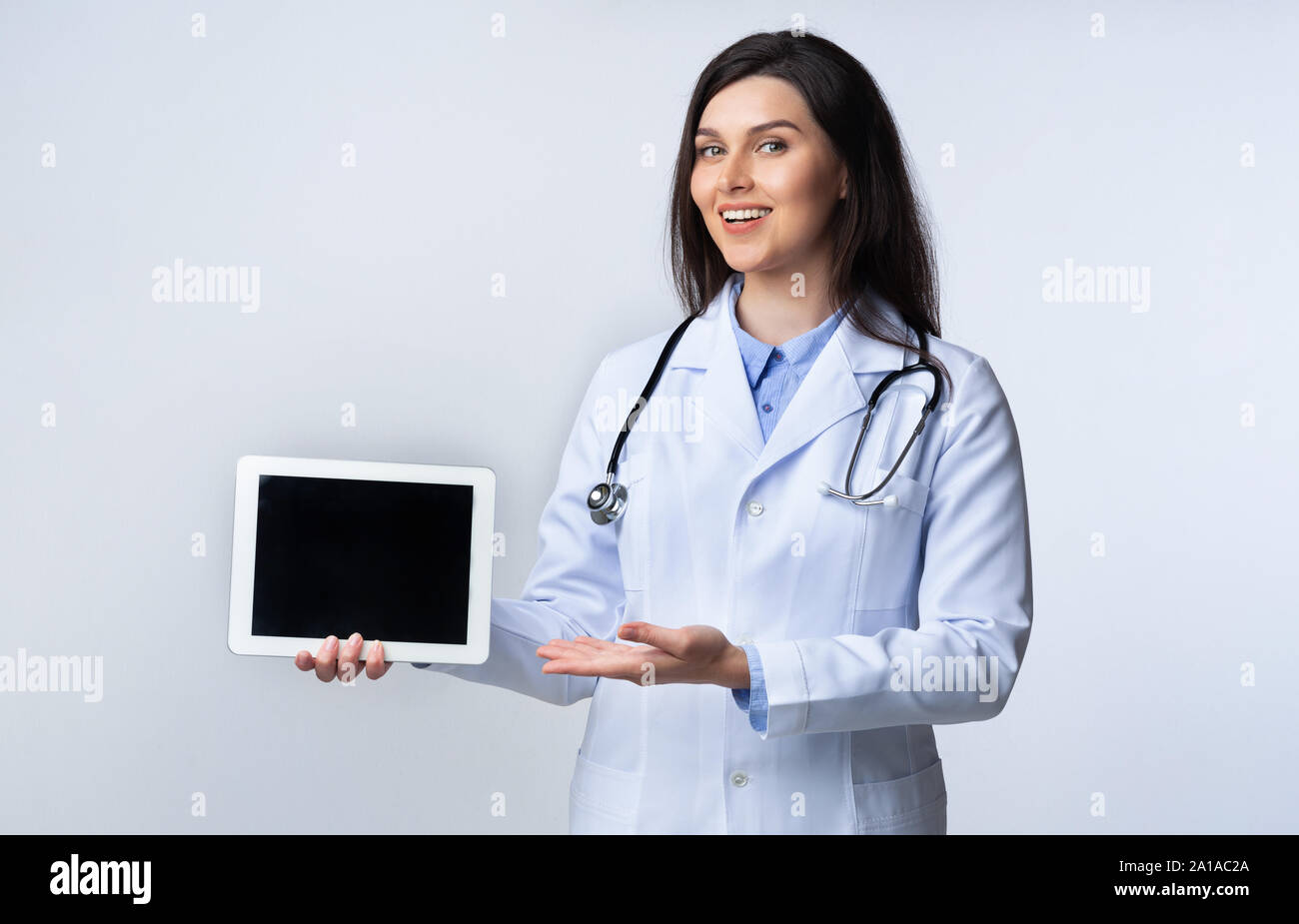 Smiling Medical Student Using Tablet Giving Presentation, Studio Shot Stock Photo