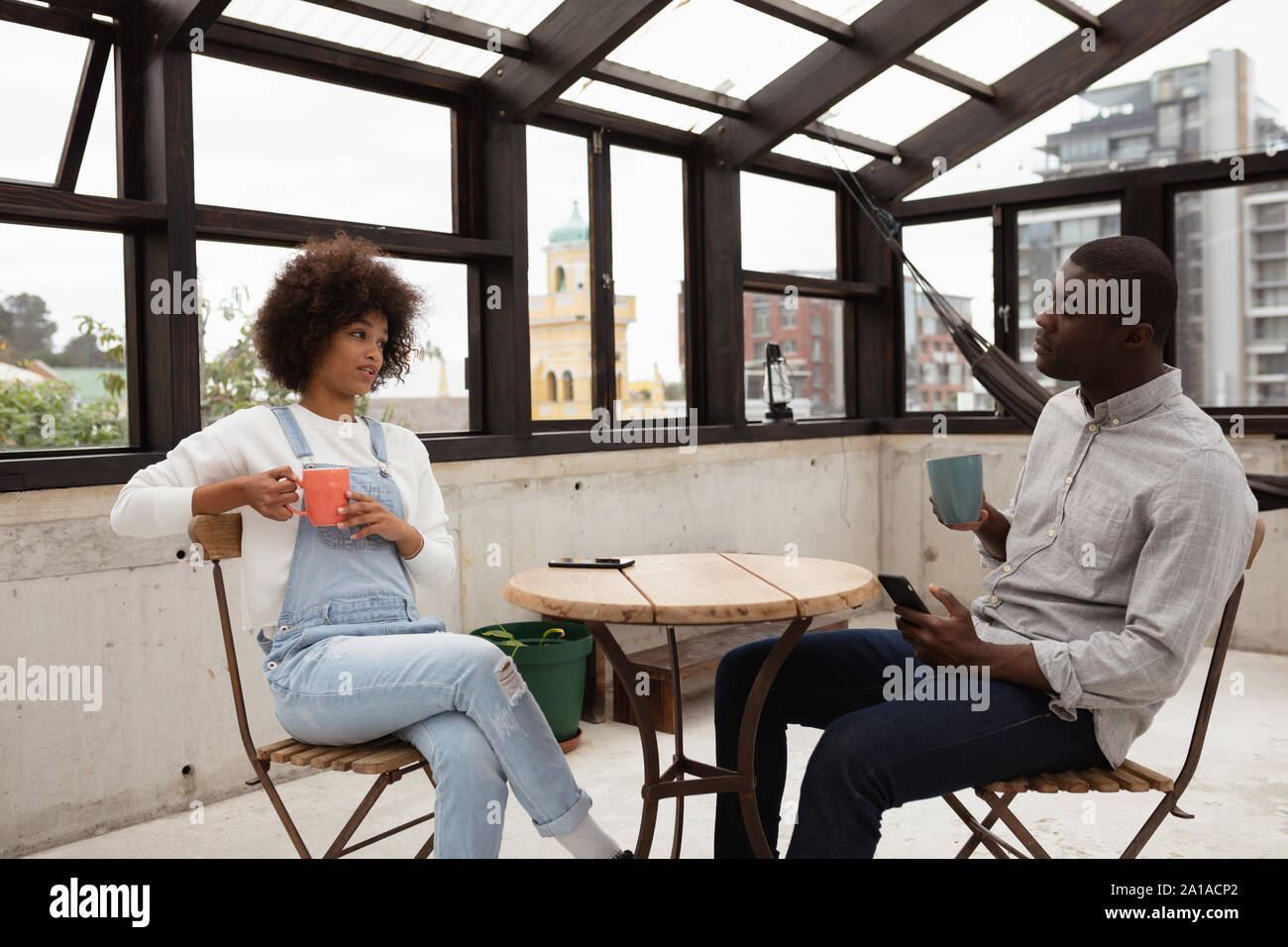 Couple drinking coffee and talking at a table Stock Photo