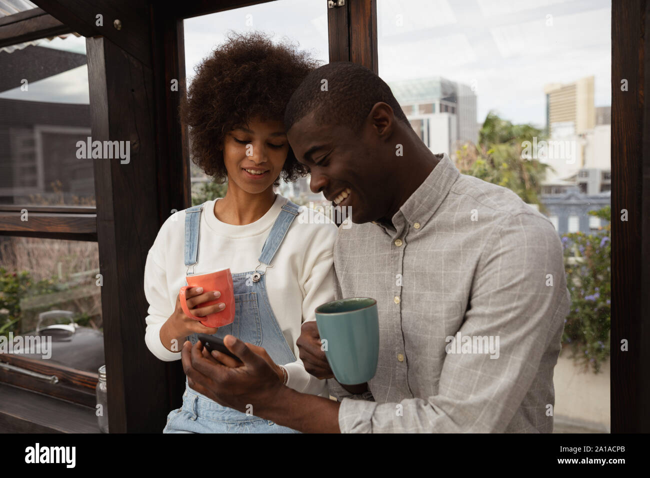Couple drinking coffee and using smartphone Stock Photo