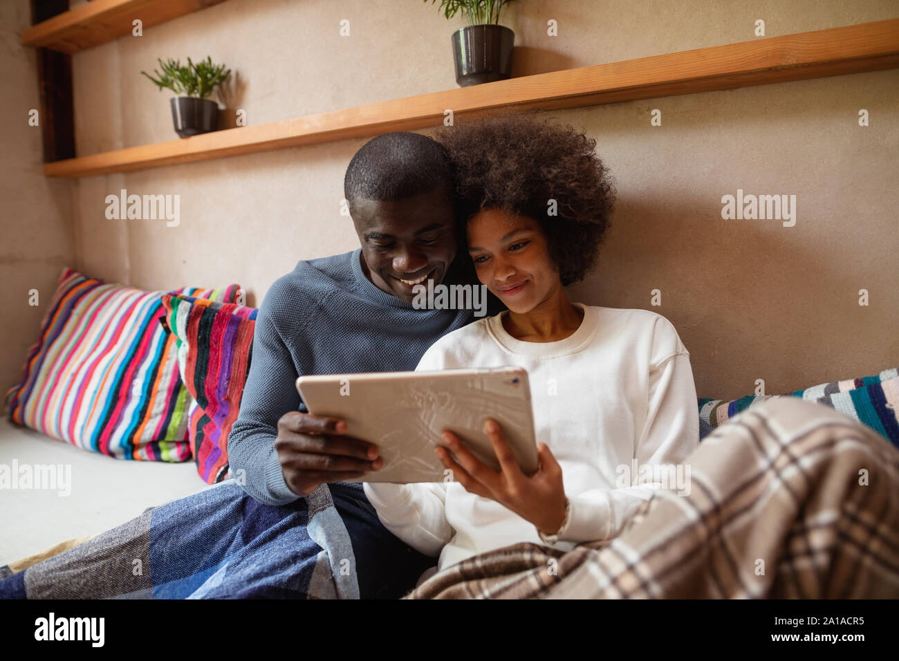 Couple using a tablet on a sofa Stock Photo