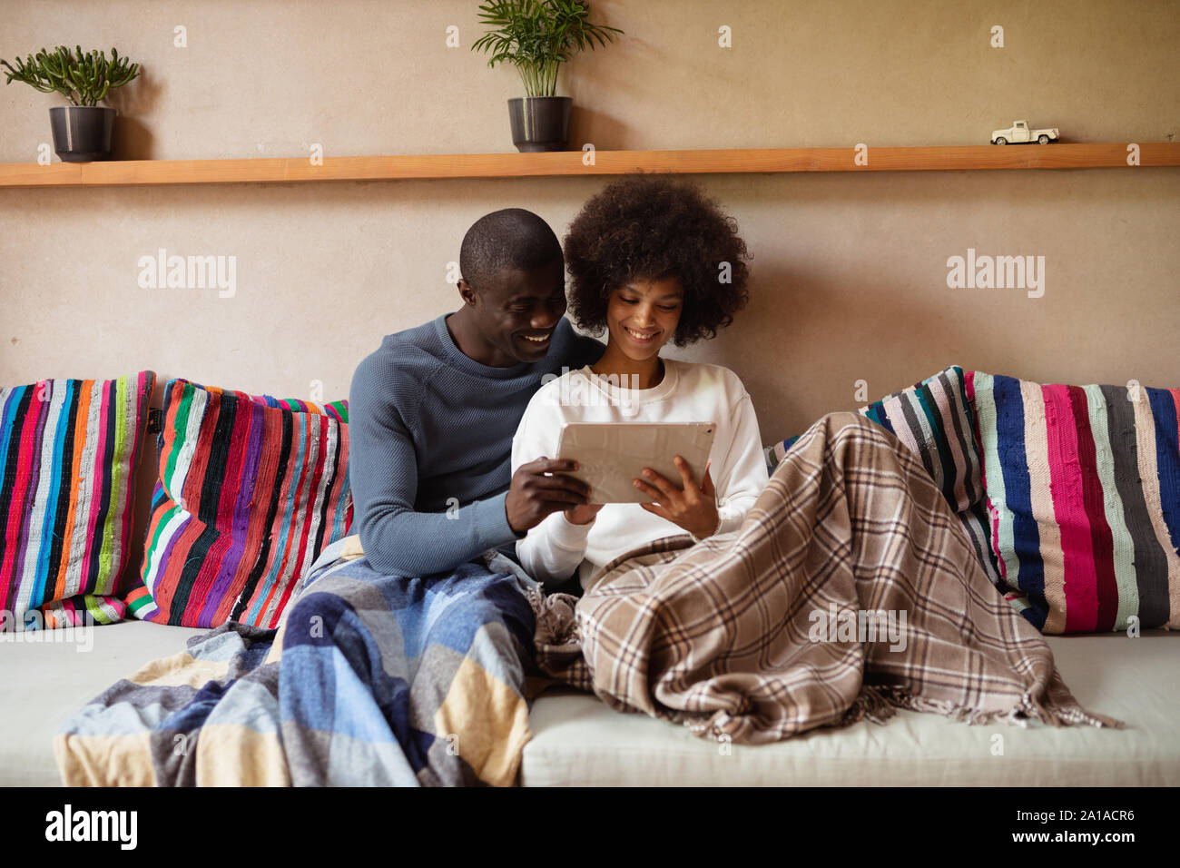 Couple using a tablet on a sofa Stock Photo