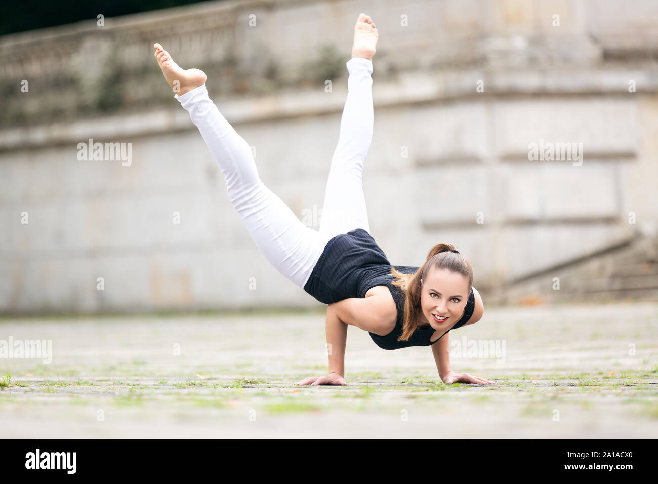 Beautiful gymnastic acrobat practicing outdoors Stock Photo
