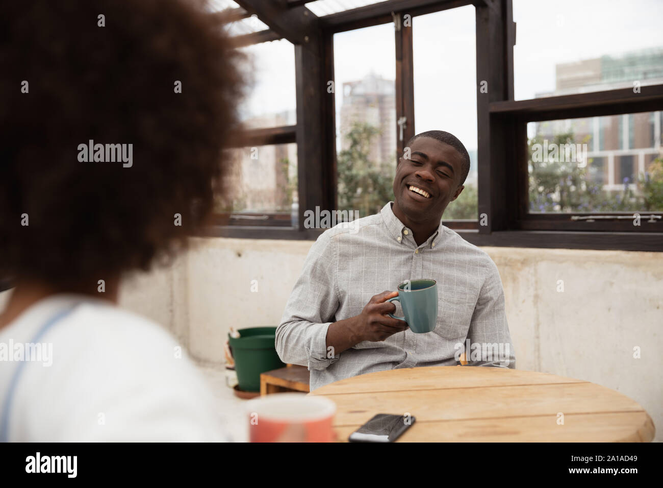 Couple drinking coffee and talking at a table Stock Photo