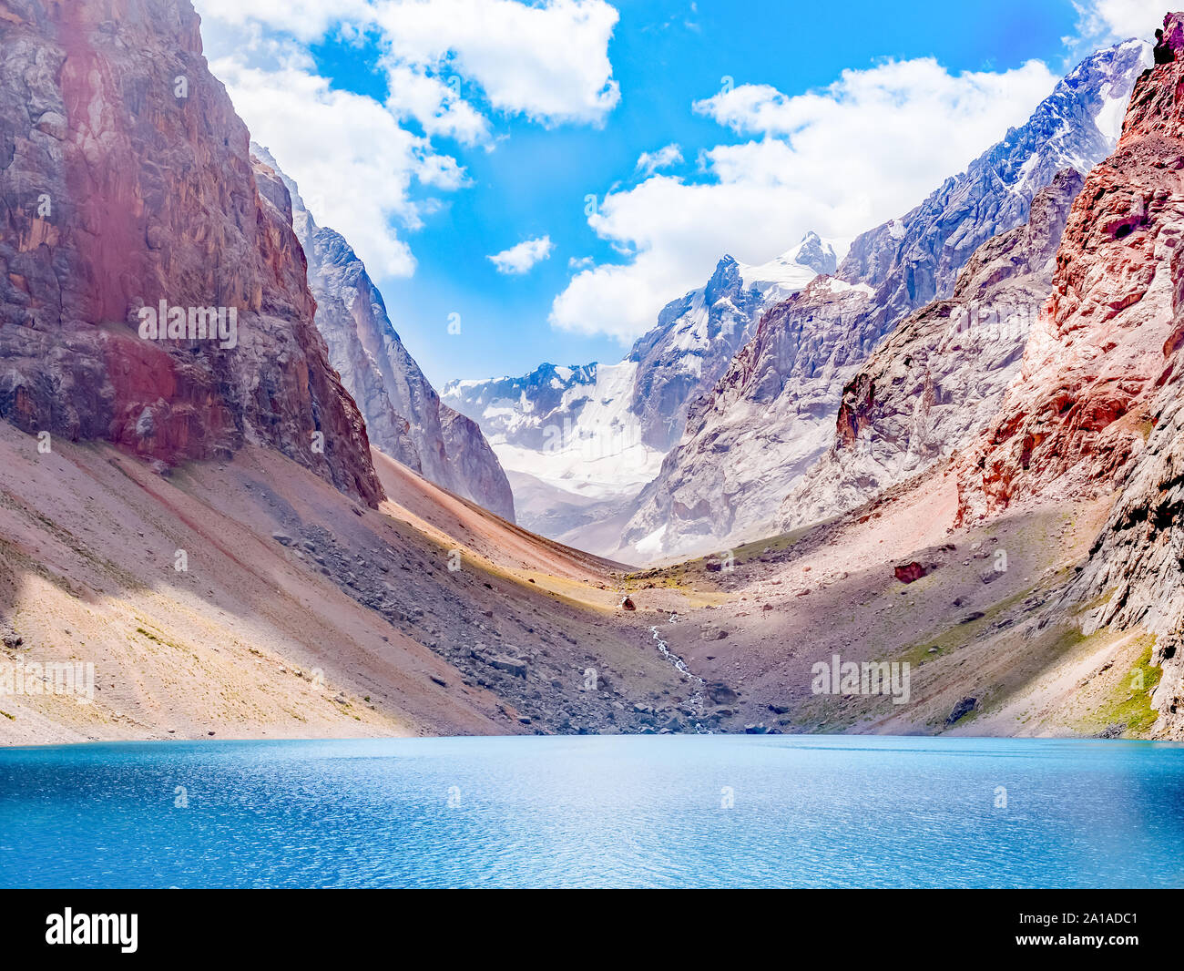 Big Alo mountain lake with turquoise water in sunshine on rocky mountain background. The Fann Mountains, Tajikistan, Central Asia Stock Photo