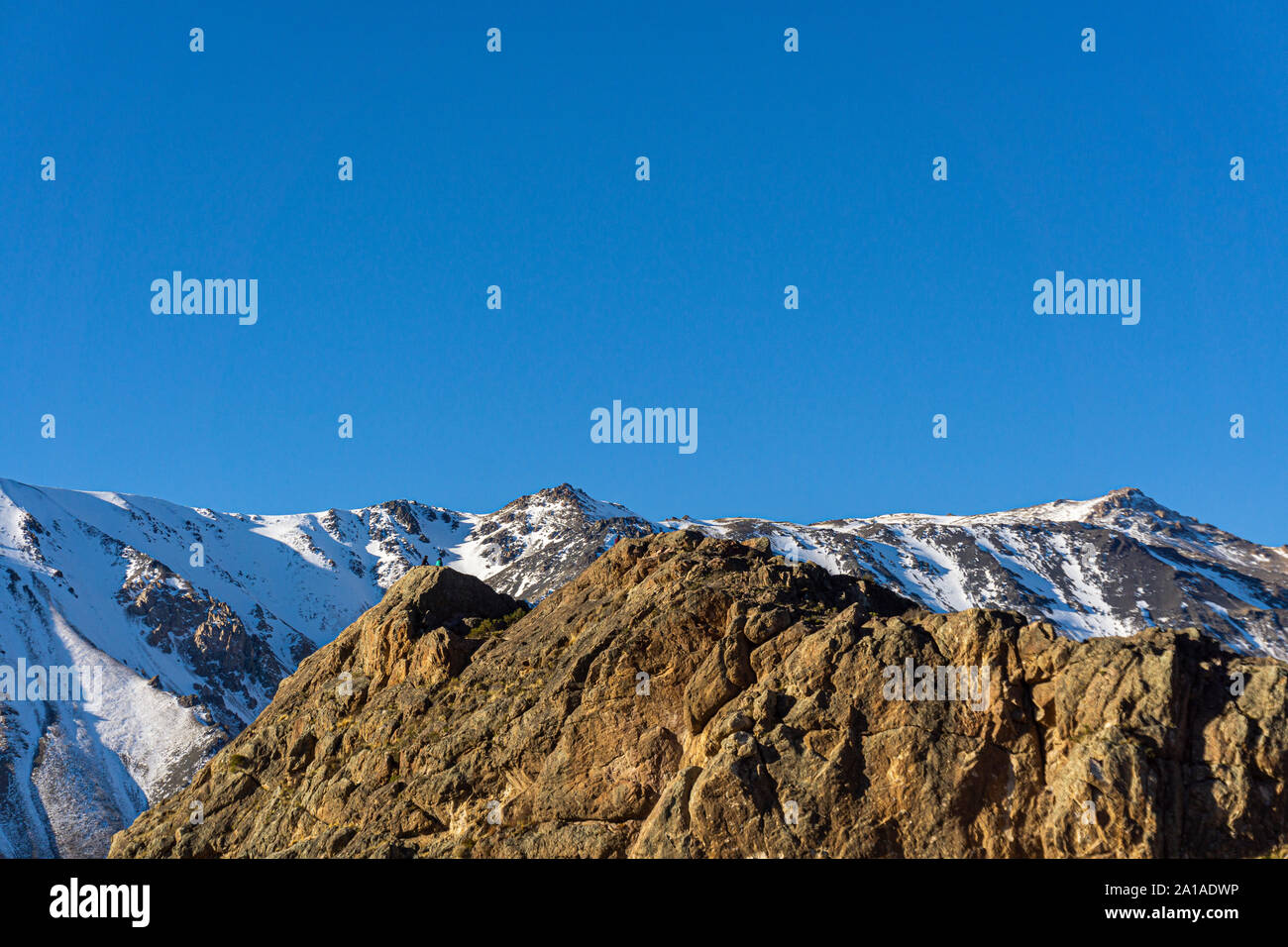 Scene view of mountain climbers reaching mountain peak against snow-capped Andes mountains in Patagonia, Esquel, Argentina Stock Photo