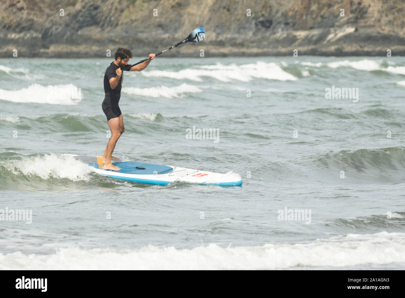 Travel and Tourism in the UK: A man with his paddleboard at Newport (Trefdraeth) Pembrokeshire, West Wales, August  2019 Stock Photo