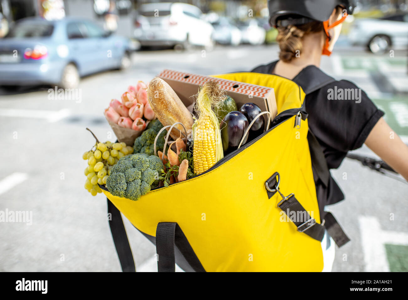 Female courier carrying backpack full of fresh products