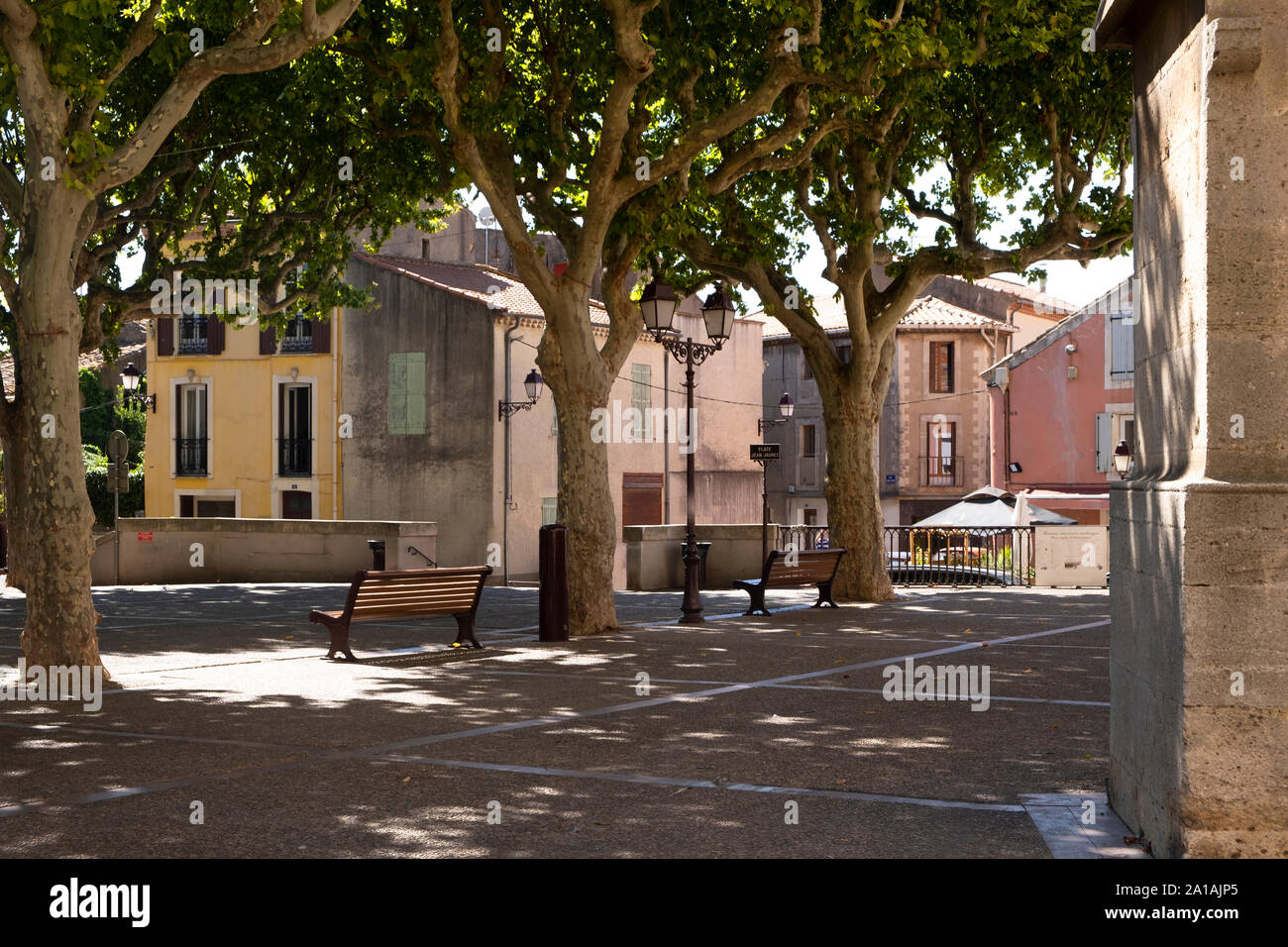 Capestang, Occitanie, France. Place Jean Jaures is the central square in the pretty Languedoc town , with typical plane trees giving welcome shade Stock Photo
