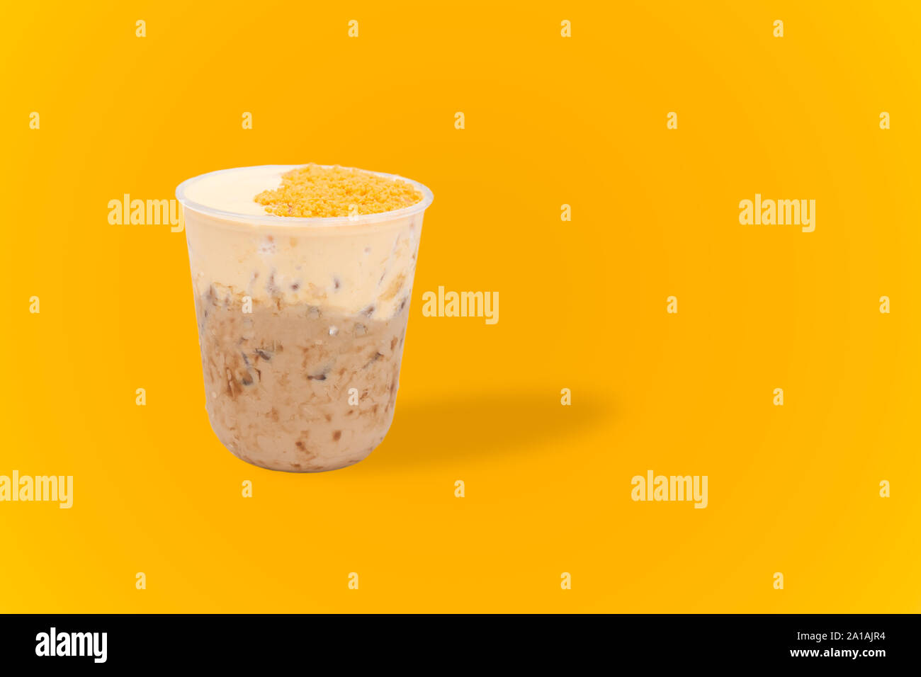 Iced milk tea with salty egg isolated in yellow background. Stock Photo