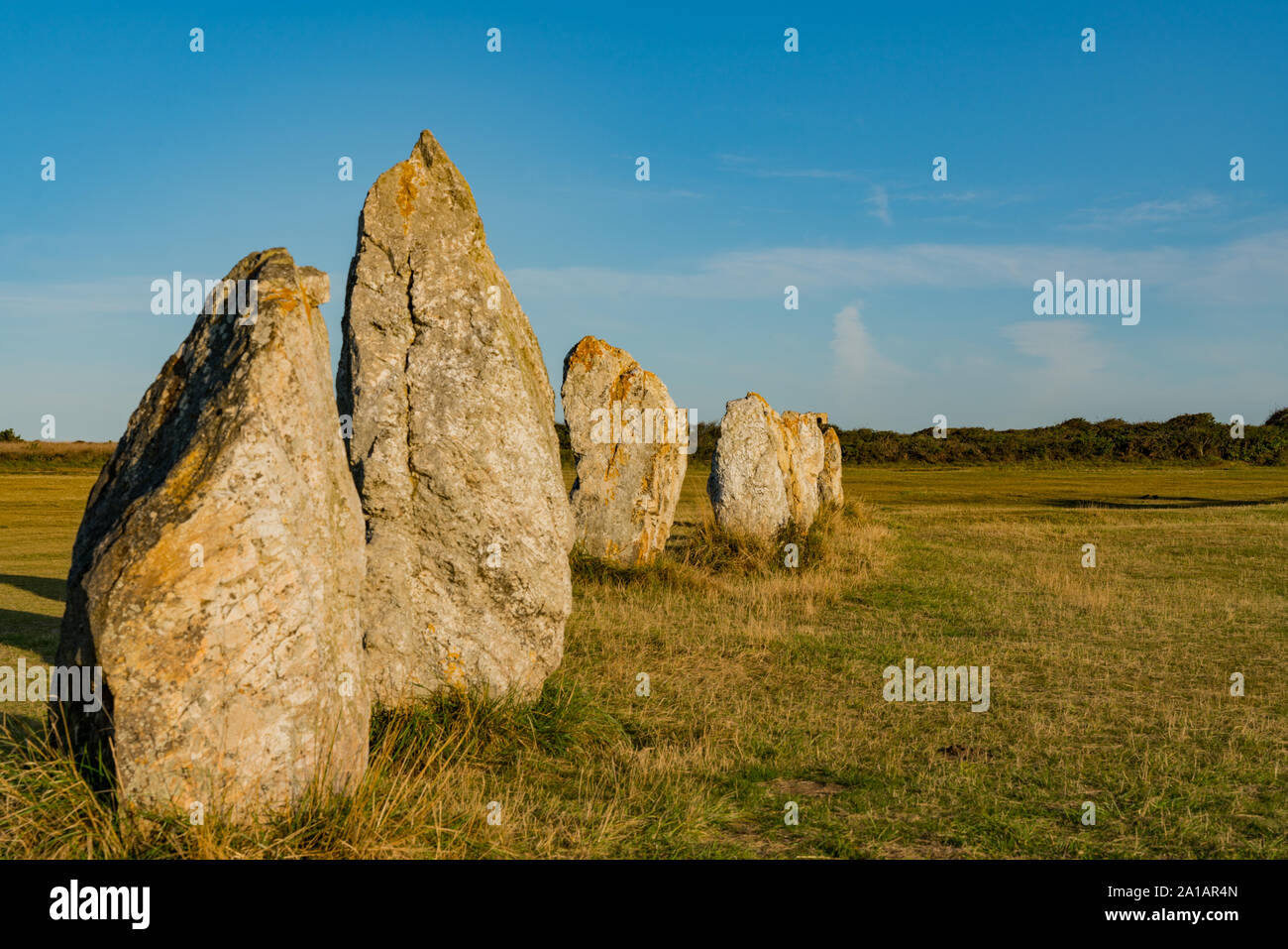view of prehistoric monolith stone alignments in Brittany in warm morning light with the sun shining brightly Stock Photo