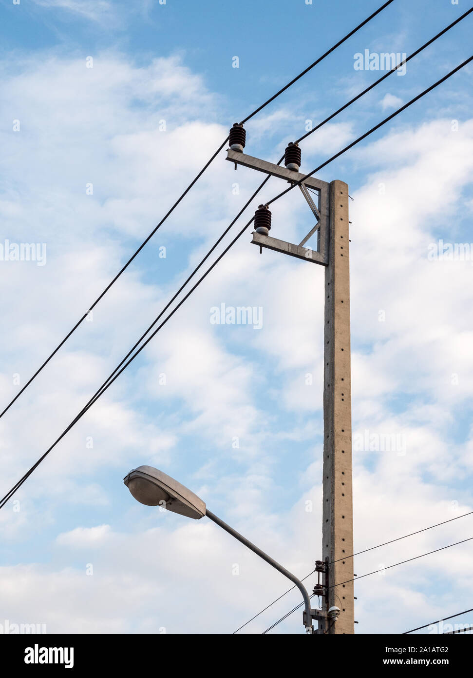 Concrete electric pole with the electric bulb near the urban street