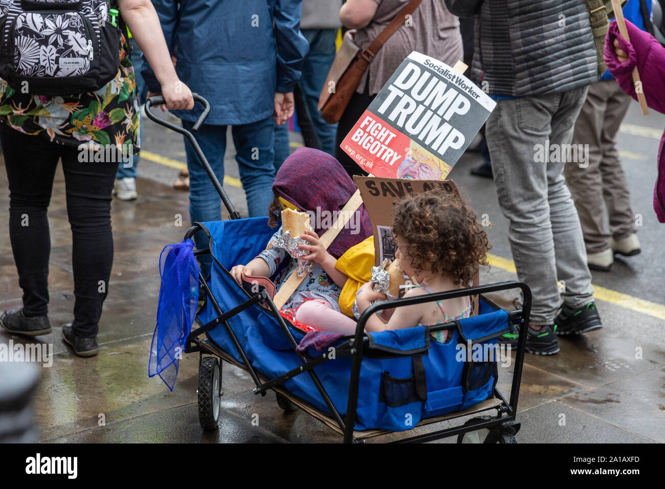 Two young children holding banners during an Anti Trump protest in Central London on June 4th 2019, during President Trump's London visit. Stock Photo