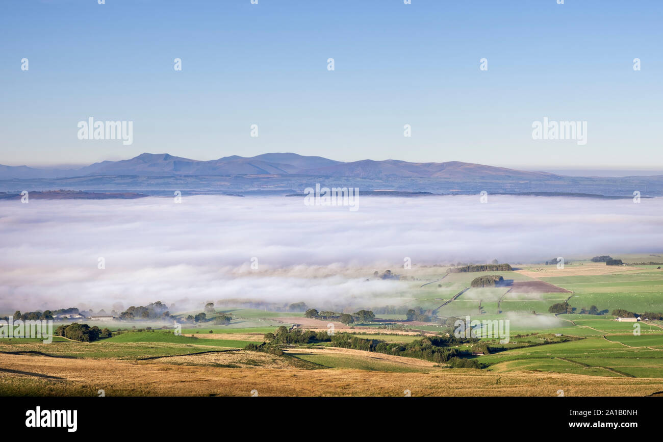 View over mist / temperature inversion in the Eden Valley Cumbria towards the North Eastern Lake District Fells from Hartside in the Northern Pennines Stock Photo