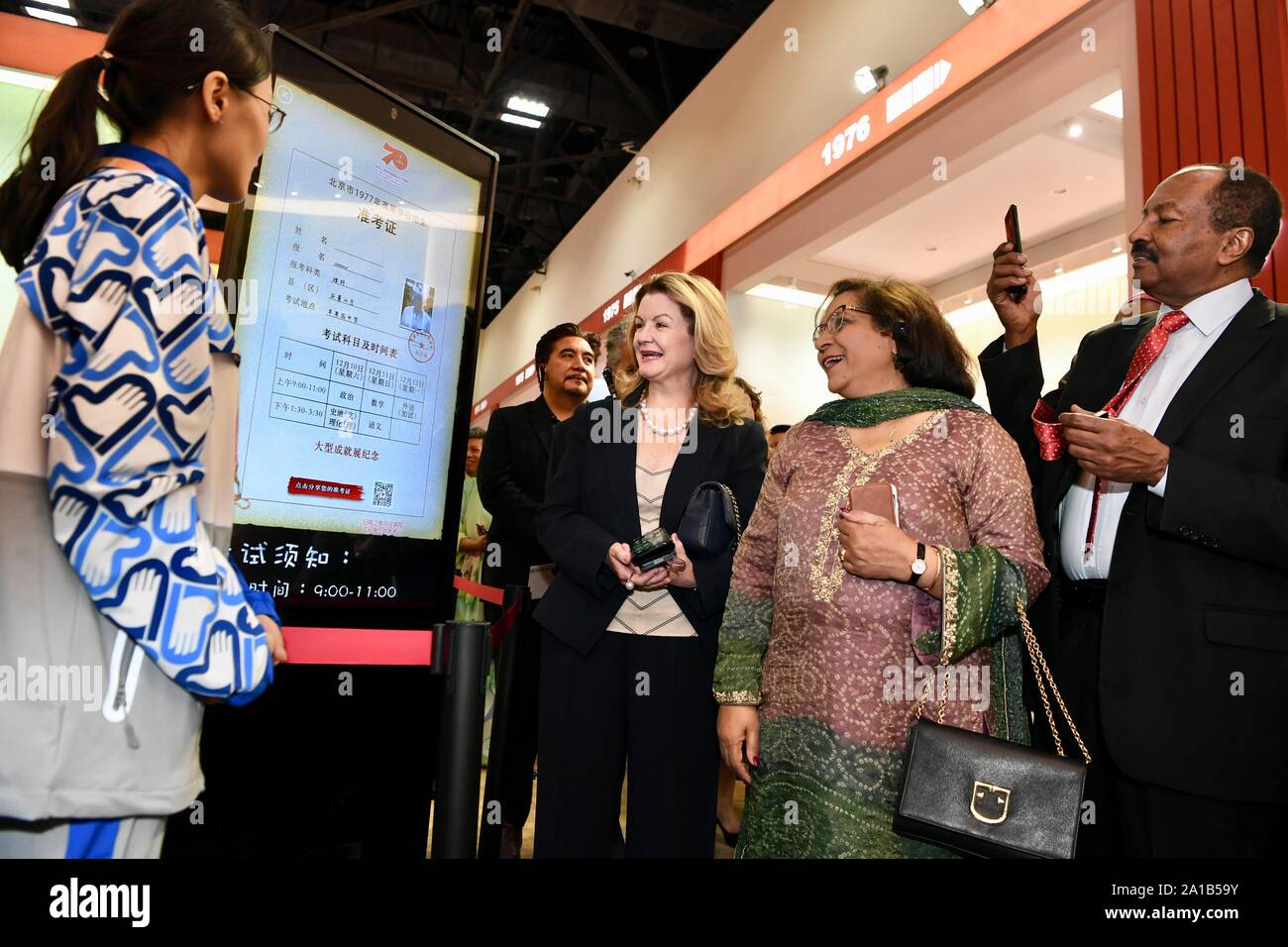 Beijing, China. 25th Sep, 2019. Foreign ambassadors, diplomats and guests view an interact display showing China's national college entrance examination in 1977 at a grand exhibition of achievements in commemoration of the 70th anniversary of the founding of the People's Republic of China (PRC) at the Beijing Exhibition Center in Beijing, capital of China, Sept. 25, 2019. Credit: Jiang Kehong/Xinhua/Alamy Live News Stock Photo