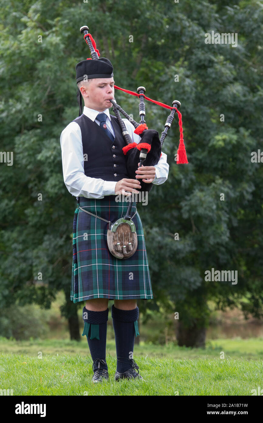 Young man from the Camelon and District Pipe Band playing the bagpipes at the Peebles highland games. Scottish borders, Scotland Stock Photo
