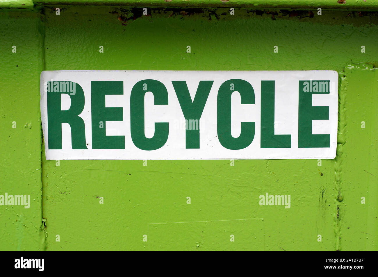Closeup of a bright green recycle sign on a metal recycling container Stock Photo