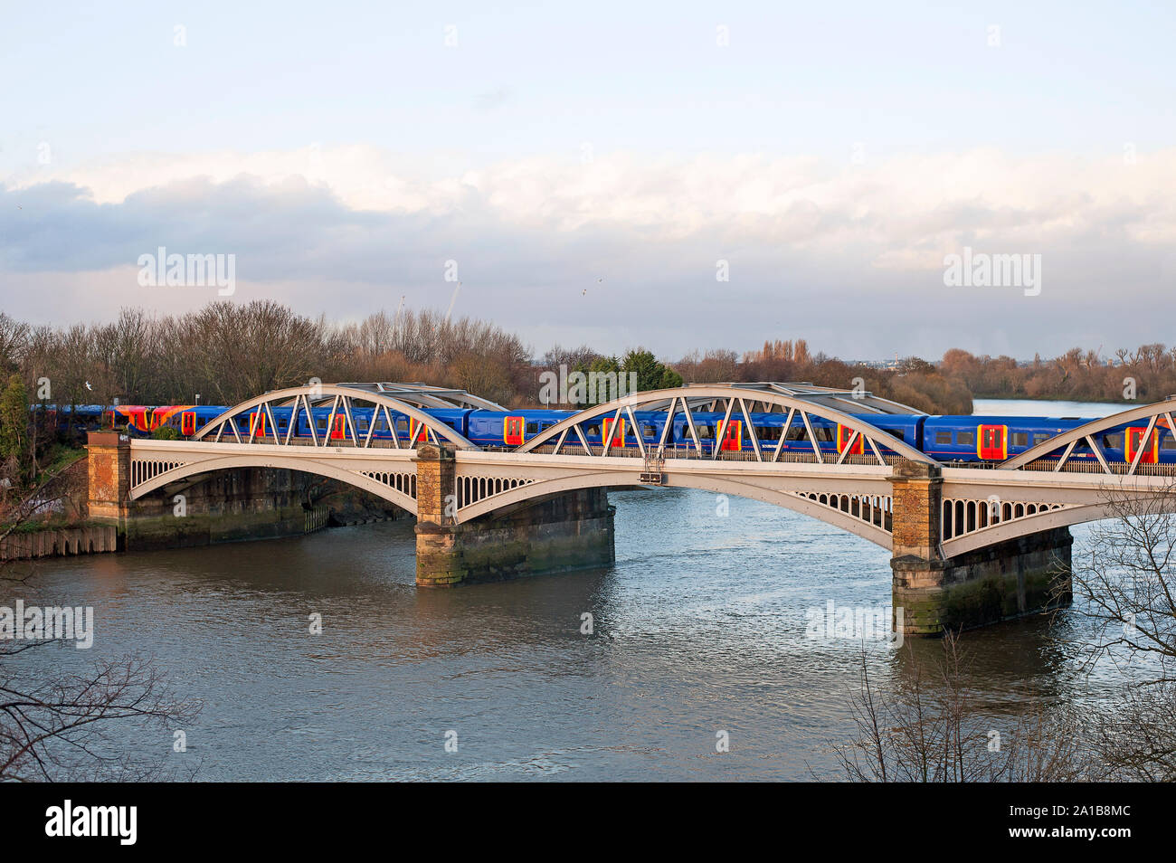 Elevated view of west side of Barnes Railway  Bridge, London SW13 over the River Thames with train crossing. Stock Photo