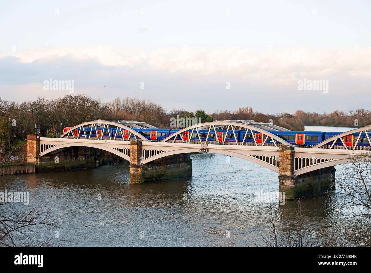 Elevated view of west side of Barnes Railway  Bridge, London SW13 over the River Thames with train crossing. Stock Photo