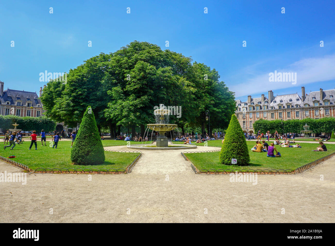 Summer in Place des Vosges-Image captured during a wonderful sunny day strollexploring anddiscovering thepark's beautyand the surrounding neighborhood. Stock Photo
