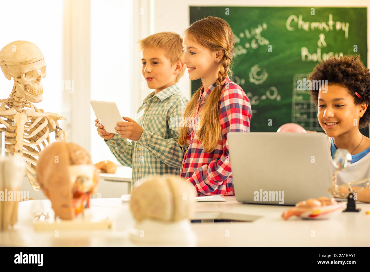 Happy kids using modern gadgets during studying Stock Photo Alamy