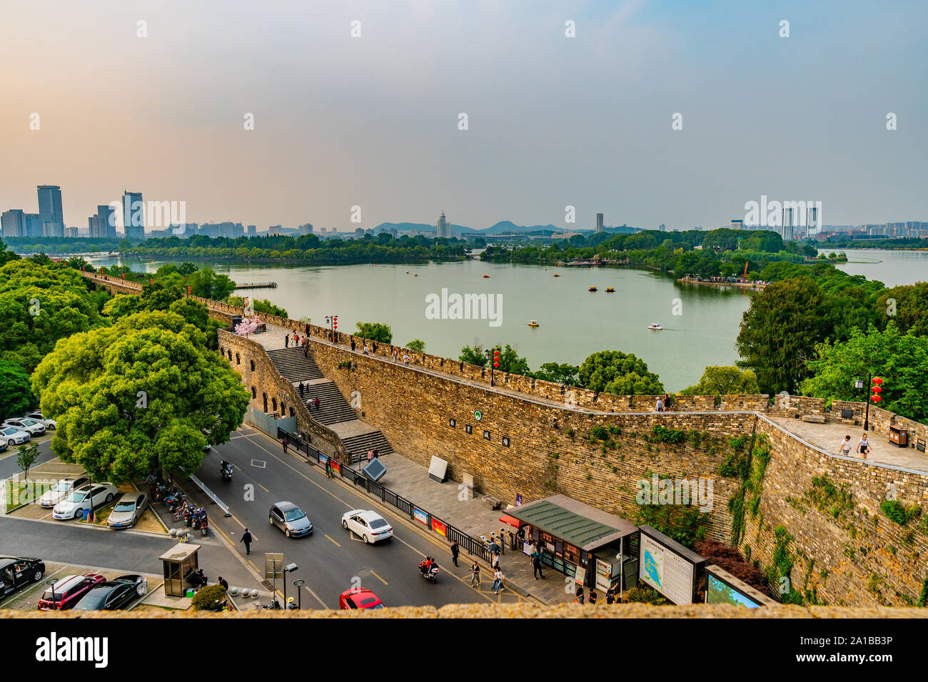 High Angle View of Nanjing Xuanwu Lake Park with Driving Cars Motorbikes and People Walking on the Wall at Afternoon Stock Photo