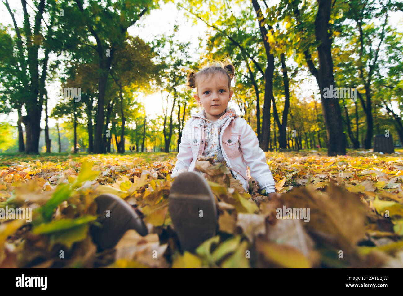 little smiling blond cute toddler girl at autumn city park Stock Photo ...