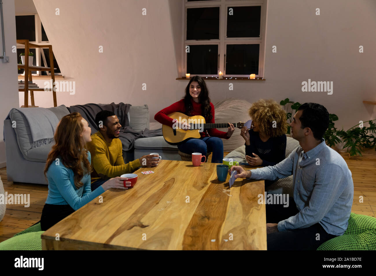 Millennial adult friends socialising together at home Stock Photo
