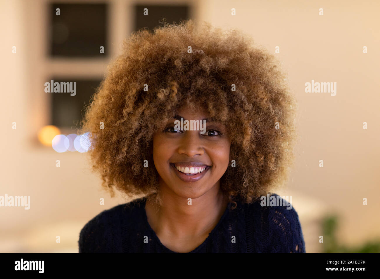 Portrait of millennial woman smiling at home Stock Photo