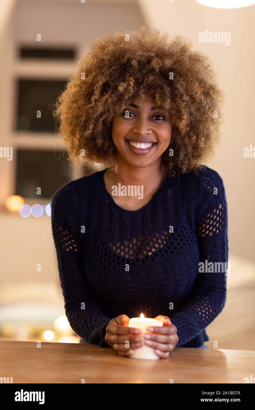Portrait of millennial woman holding candle at home Stock Photo
