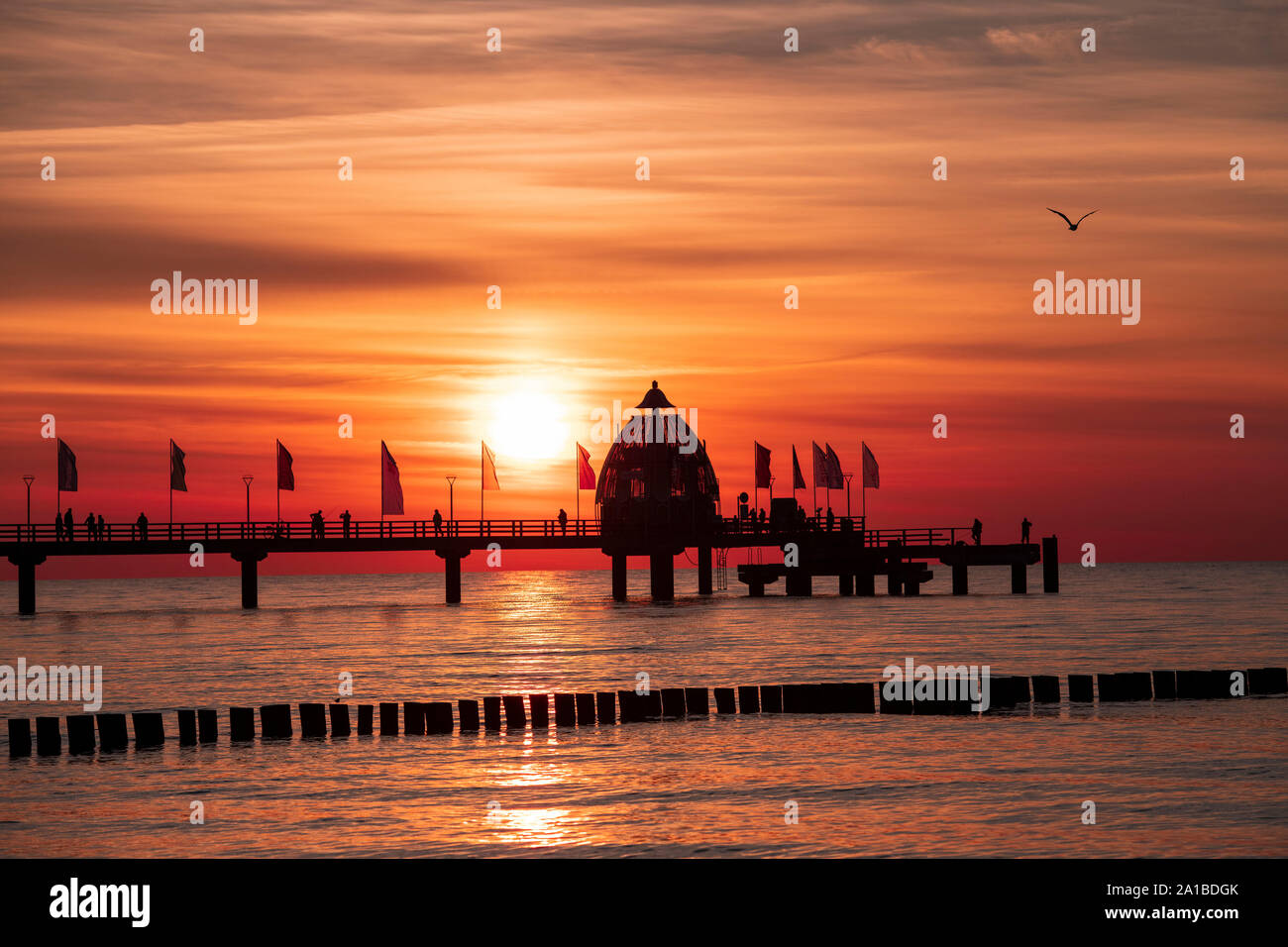 Sea bridge with diving gondola in Zingst in front of the beautiful sunset. Silhouette of the sea bridge before the skyline at the German Baltic Sea. Stock Photo