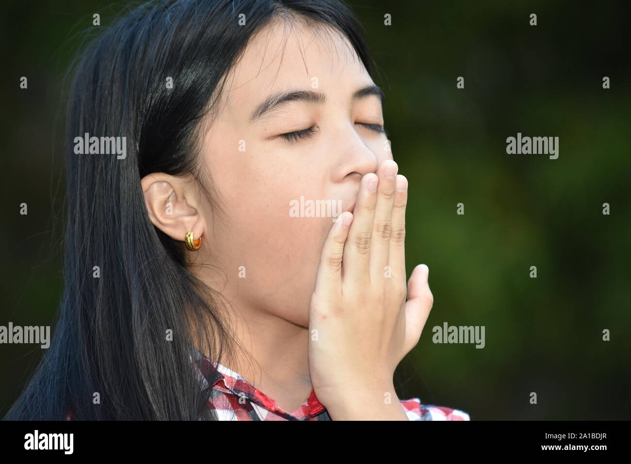 A Young Filipina Juvenile Yawning Stock Photo