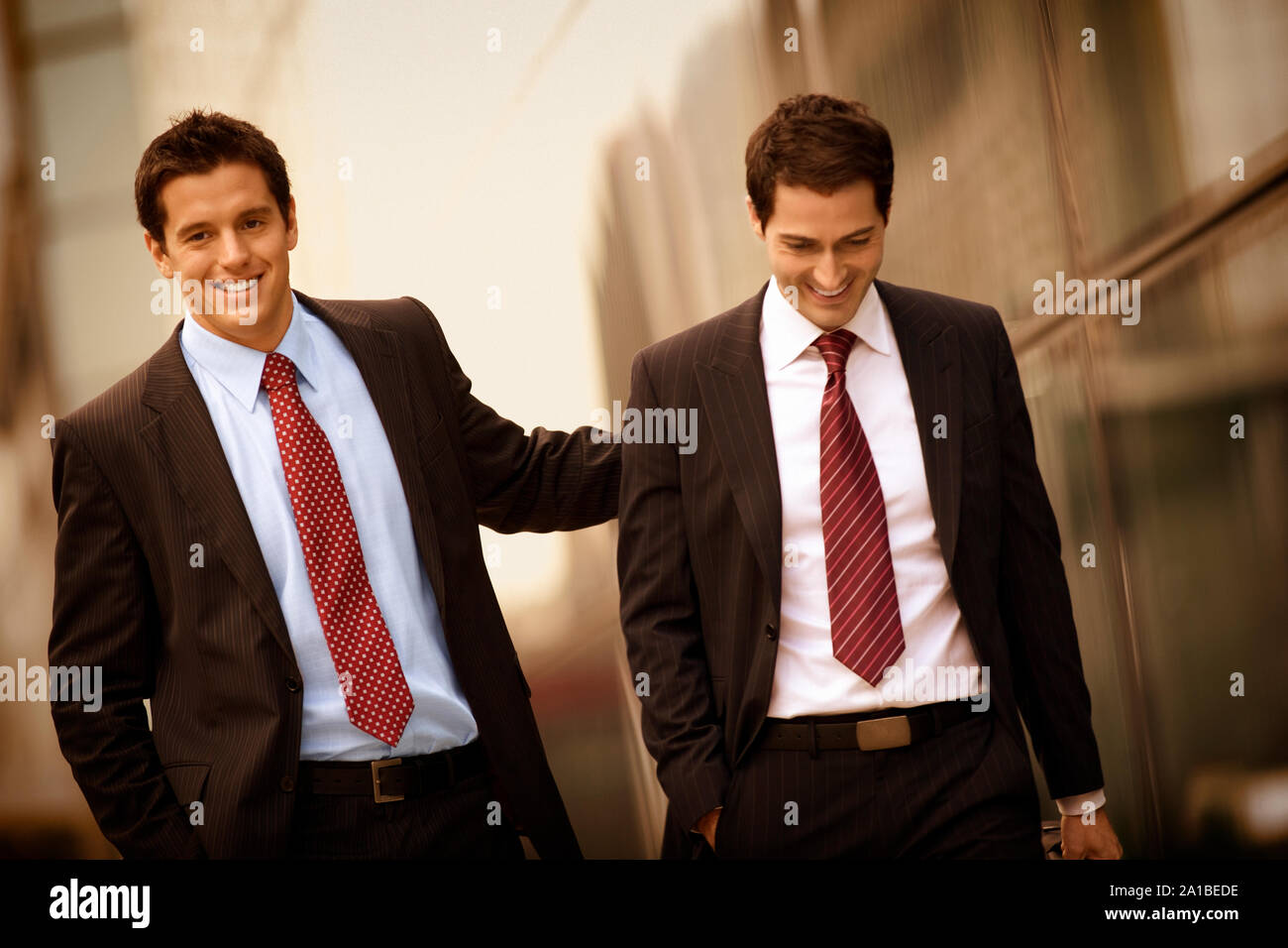 Businessmen walking and talking together Stock Photo - Alamy