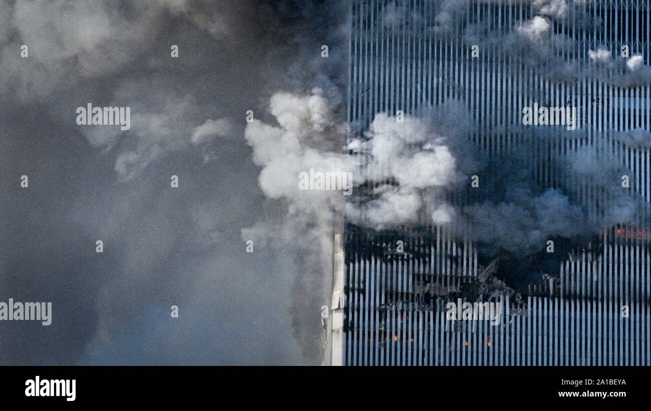 Two commercial jetplanes crashed into each of twin towers of the World Trade Center in a coordinated terror attack orchestrated by Osama Bin Laden. People are waving from the windows above the impact hole in the south tower of World Trade Center in Manhattan. Stock Photo