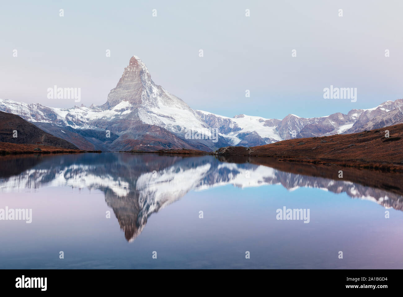 Picturesque landscape with colorful sunrise on Stellisee lake. Snowy Matterhorn Cervino peak with reflection in clear water. Zermatt, Swiss Alps Stock Photo