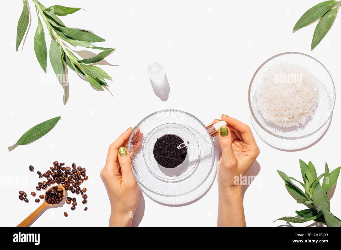 Woman's hands adding oil using pipette into ground coffee leftovers to