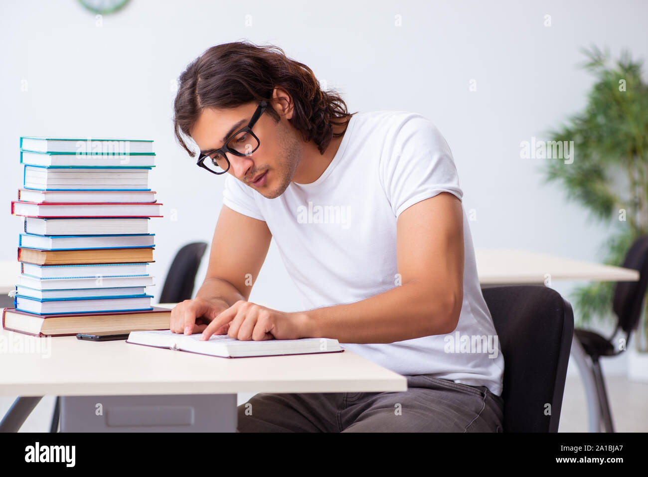 The young male student sitting in the classroom Stock Photo - Alamy