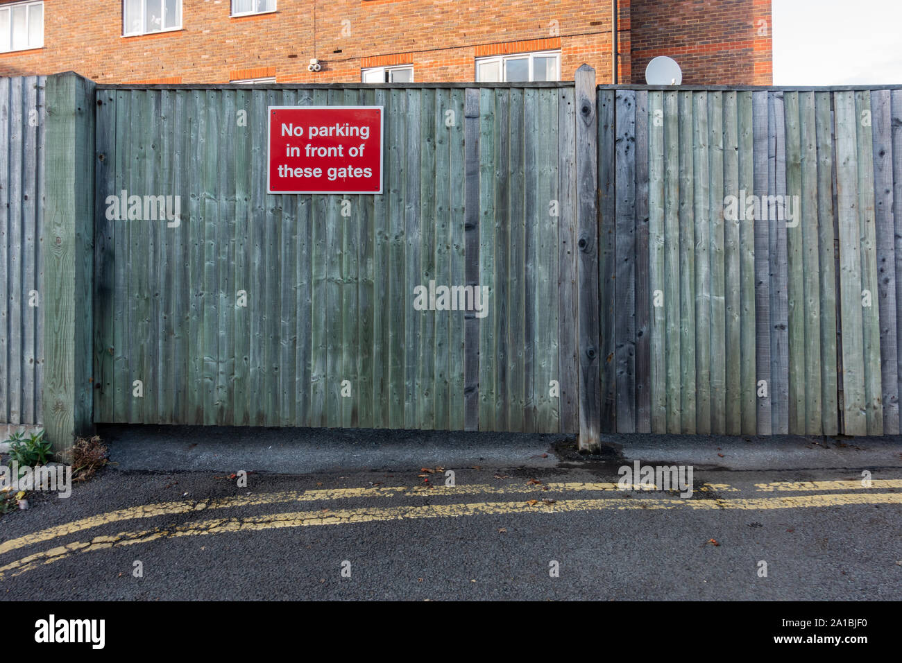 A no parking sign attached to a wooden gate Stock Photo