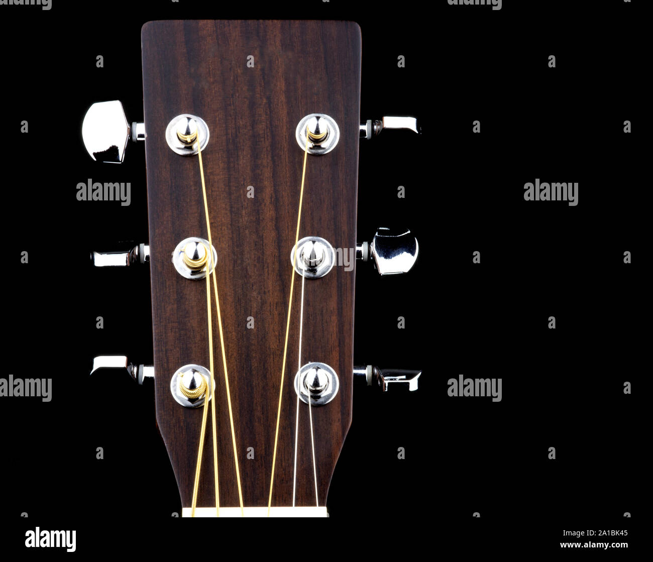 Acoustic guitar peg head isolated against a black background Stock