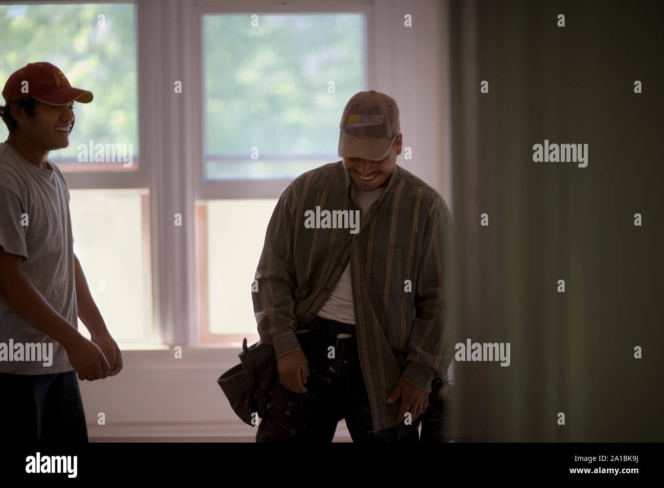 Two male builders sharing a joke. Stock Photo