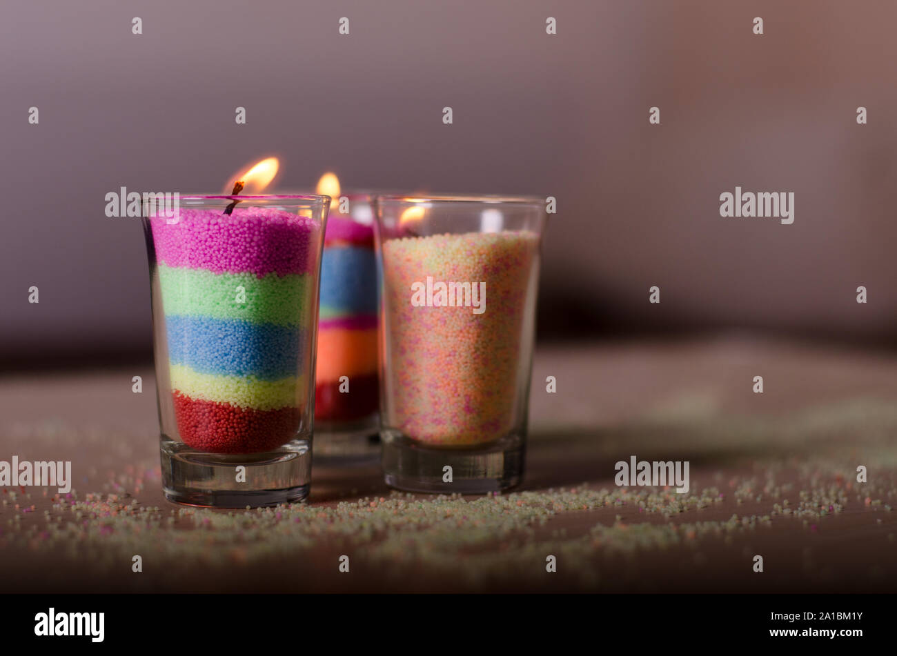 Three Homemade candles from colored granulated wax in a glasses Stock