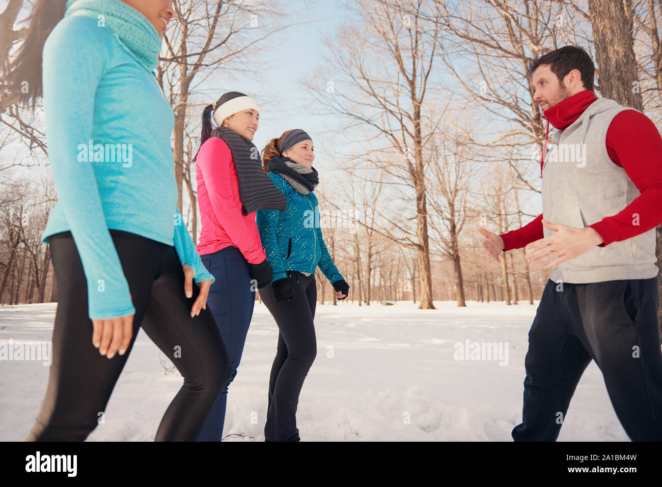 Group of friends stretching in the snow in winter Stock Photo