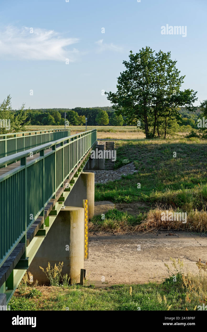 The river 'Schwarze Elster' near Senftenberg has dried up, consequence of the hot summer 2019, view of the waterless riverbed near a bridge, yardstick Stock Photo