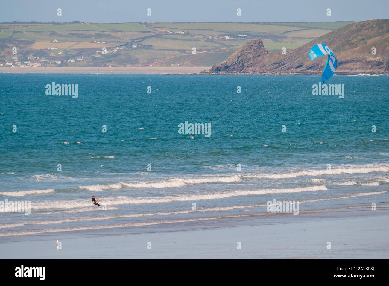 A man kite surfing on the sea at Little Haven, on the coast of St Bride's Bay, Pembrokeshire National Park, South West Wales UK Stock Photo